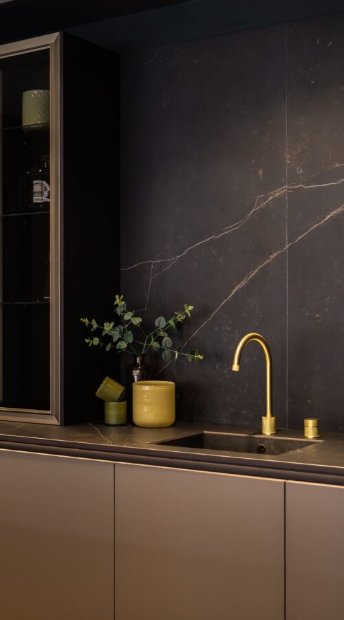 neoLODGE kitchen in Blackened Oak with gold tap and glass showcase cabinets