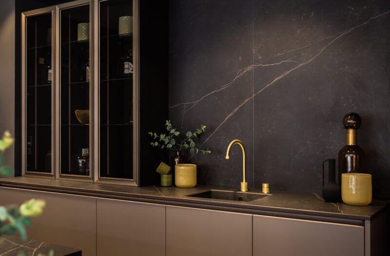 neoLODGE kitchen in Blackened Oak with gold tap and glass showcase cabinets